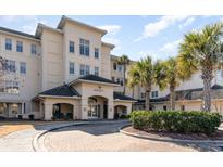 Inviting condo exterior with a brick drive, lush landscaping, and a charming entrance beneath a covered archway at 2180 Waterview Dr. # 727, North Myrtle Beach, SC 29582