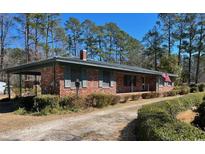 Charming brick ranch-style home featuring a well-manicured lawn and a quaint, inviting entrance at 2501 Main St., Loris, SC 29569