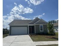 Charming single-story home featuring an attached garage, well-maintained lawn, and inviting curb appeal on a sunny day at 360 Kapalua Loop, Little River, SC 29566