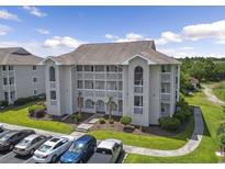 Low angle view of condominium featuring multiple stories, balconies, and landscaping at 4405 Eastport Blvd. # D-8, Little River, SC 29566