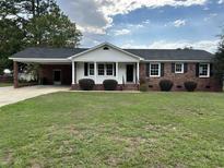 Charming one-story brick home with a well-maintained lawn and a covered parking area at 506 Byrnes Circle, Johnsonville, SC 29555