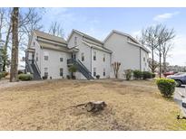 Exterior view of a two-story residential building with gray siding and stairs leading to the upper units at 506 Spa Dr. # 506, Little River, SC 29566