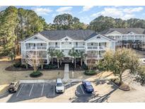 Beautiful condominium complex with white balconies, mature trees, and convenient parking at 5825 Catalina Dr. # 511, North Myrtle Beach, SC 29582