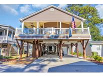 Inviting two-story home featuring a charming porch, sturdy pilings, and a cozy outdoor entertainment space at 6001-O32 S Kings Hwy., Myrtle Beach, SC 29575