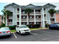 Three-story condo building with white pillars and private balconies, nestled among lush greenery and palm trees at 602 Waterway Village Blvd. # 30-F, Myrtle Beach, SC 29579