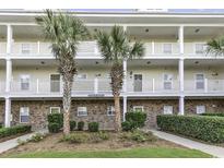 Inviting condo exterior featuring multiple balconies, classic brick accents, and lush landscaping at 6253 Catalina Dr. # 921, North Myrtle Beach, SC 29582