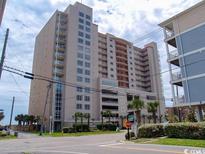 Stunning exterior view of a high-rise building with a parking garage and palm trees at 1401 S Ocean Blvd. S # 1003, North Myrtle Beach, SC 29582