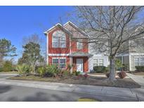 Charming two-story townhome featuring a red exterior, well-manicured landscaping, and a welcoming front entrance at 1654 Low Country Pl. # F End, Myrtle Beach, SC 29577