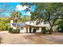 Two-story home featuring a stucco exterior, a palm tree in the front yard, and mature trees in the surrounding landscape at 212 78Th Ave. N, Myrtle Beach, SC 29572