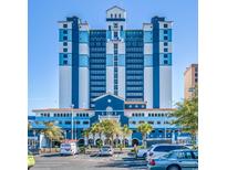 The blue and white exterior of a beachfront building is seen on a clear, sunny day at 2201 S Ocean Blvd. # 1603, Myrtle Beach, SC 29577