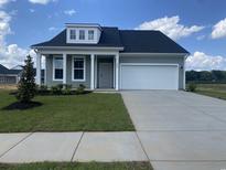 Charming, single story home features a 1-car garage, light green siding and covered front porch at 242 Letha Dr, Longs, SC 29568