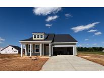 Charming single-story home with gray siding, covered porch, and attached two-car garage at 242 Letha Dr, Longs, SC 29568