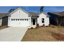 Charming single-story home with a white facade, attached garage, and well-maintained lawn at 293 Eagle Claw Dr., Calabash, NC 28467