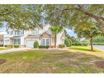Charming two-story home featuring a well-manicured lawn, attached garage, and tasteful landscaping at 307 River Rock Ln. # 906, Murrells Inlet, SC 29576