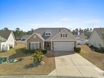 Charming single-story home with neutral siding, well-manicured lawn and a two-car garage at 556 Cedar Lakes Dr., Little River, SC 29566