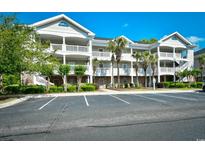 Attractive condo building with multiple balconies and mature landscaping near parking lot at 5801 Oyster Catcher Dr. # 723, North Myrtle Beach, SC 29582