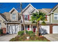 Charming townhome with a well-maintained front yard, a palm tree, and a two-car garage at 592 Riverward Dr. # 592, Myrtle Beach, SC 29588