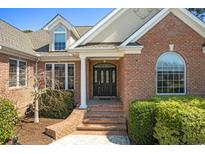Charming brick home featuring a classic front door and well-maintained landscaping at 598 Summer Green Ct., Sunset Beach, NC 28468