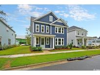 Charming two-story blue home with manicured lawn, complemented by white trim and welcoming porch at 67 Bridgeview Rd., Georgetown, SC 29440