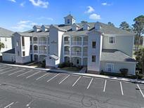 Exterior of condo building showing facade, balconies, and parking area on a sunny day at 1009 World Tour Blvd. # 103, Myrtle Beach, SC 29579