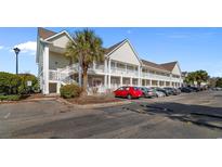 A condo exterior shows multiple units with parking and lush landscaping at 117 Butkus Dr. # 1, Myrtle Beach, SC 29588