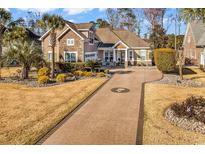Beautiful home with a stone facade, well-manicured lawn, and a long driveway with a custom design at 120 Henry Middleton Blvd., Myrtle Beach, SC 29588