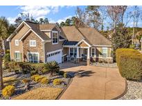 Charming home featuring stone accents, a well-manicured lawn, and a spacious driveway leading to an attached garage at 120 Henry Middleton Blvd., Myrtle Beach, SC 29588