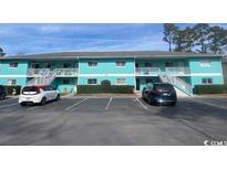 Two-story building has a colorful facade, staircase access, and ample parking at 1200 5Th Ave. N # 1407, Surfside Beach, SC 29575