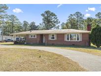 Charming brick home with covered parking, circular driveway and lush surroundings at 1301 Highway 701 South, Loris, SC 29569