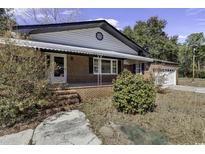 Charming brick home with awning and landscaping, offering classic curb appeal and a welcoming entrance at 1455 Jackson Village Rd., Georgetown, SC 29440