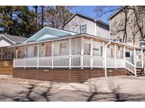 Charming beach house featuring a light blue exterior, white porch and a welcoming pink door at 1733 Neptune Rd., Myrtle Beach, SC 29575