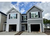 New construction townhomes with gray siding and a one car garage under a cloudy blue sky at 262 Christiana Ln. # A, Myrtle Beach, SC 29579