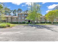 Attractive three-story condo building with well-maintained landscaping and ample parking space at 340 Myrtle Greens Dr. # J, Conway, SC 29526