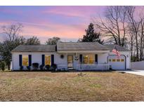 Charming single-story home with a welcoming front porch and an American flag at 356 Boxcar Dr., Longs, SC 29568