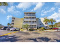 Multi-story condo building with ample parking, landscaping, and screened-in porches on every level at 4350 Intercoastal Dr. # 2301, Little River, SC 29566