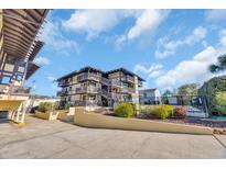 Condo building exterior showcases balconies and lush landscaping on a beautiful sunny day at 6813 Porcher Dr. # 26, Myrtle Beach, SC 29572