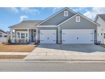 Charming home with a two-car garage, blue siding, and manicured landscaping at 892 Harrison Mill St., Myrtle Beach, SC 29579