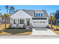 Charming white two-story home featuring a covered front porch and a two car garage at 9035 Binnicker Dr., Murrells Inlet, SC 29576