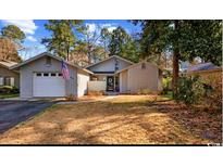 Charming single-story home featuring a one car garage and an inviting front yard with mature landscaping at 954 Oakwood Ln., Myrtle Beach, SC 29572