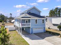 Charming coastal home featuring a spacious garage, porch, and an inviting elevated design at 108 Fincham Dr., Little River, SC 29566