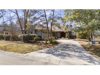 Charming single-story home with mature trees, lush landscaping, and a circular driveway at 1820 Spinnaker Dr., North Myrtle Beach, SC 29582