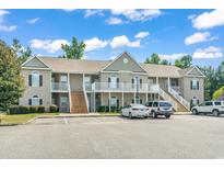 Attractive two-story condo building with private balconies and ample parking space on a sunny day at 210 Portsmith Dr. # 2, Myrtle Beach, SC 29588