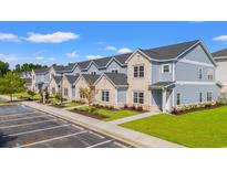 New townhomes with brick and vinyl exterior, neat landscaping, ample parking, and sidewalks under blue sky at 344 Kiskadee Loop # F, Conway, SC 29526