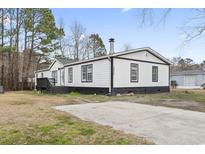 Charming single-story home with a black and white exterior and spacious concrete driveway at 3530 Reavis Ln., Myrtle Beach, SC 29579