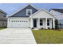 Charming two-story home with a manicured lawn and attached two-car garage, showcasing modern design at 4036 Bucolic Loop, Myrtle Beach, SC 29588