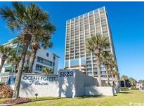 Ocean Forest Plaza condo with lush palm trees and manicured lawn under clear blue skies at 5523 North Ocean Blvd. # 2112, Myrtle Beach, SC 29577