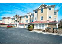 Condominium exterior featuring layered patios, red awnings and private garages at 5650 Barefoot Resort Bridge Rd. # 234, North Myrtle Beach, SC 29582