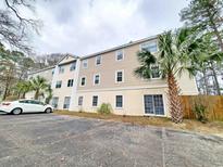 Multi-level condo building shows a well maintained exterior with palm trees and parking at 6840 Blue Heron Blvd. # 108, Myrtle Beach, SC 29588