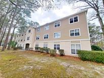 Tan exterior of the condo building features multiple windows and manicured landscaping at 6840 Blue Heron Blvd. # 108, Myrtle Beach, SC 29588