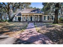 Inviting traditional home with a brick walkway, lovely lawn, and stately trees draped with Spanish moss at 762 Wraggs Ferry Rd., Georgetown, SC 29440